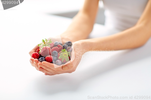 Image of close up of young woman hands holding berries