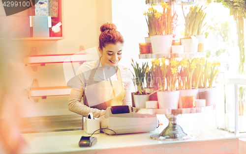 Image of florist woman at flower shop cashbox on counter