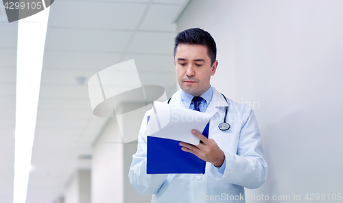 Image of doctor with clipboard at hospital corridor