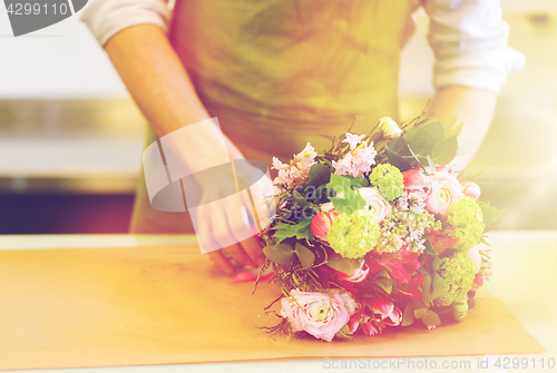 Image of florist wrapping flowers in paper at flower shop