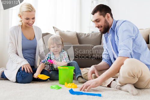 Image of happy family playing with beach toys at home