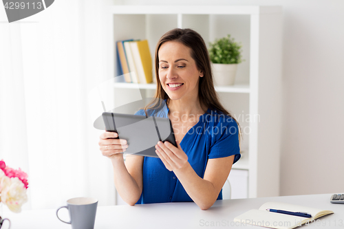 Image of woman with tablet pc working at home or office