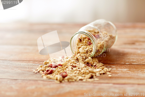 Image of jar with granola or muesli poured on table