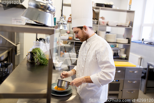 Image of chef with pot cooking and serving food at kitchen