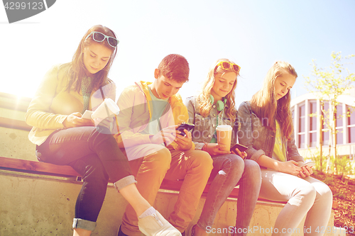 Image of teenage friends with smartphone and coffee cups