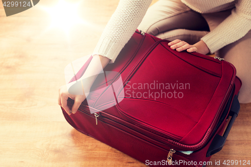 Image of close up of woman packing travel bag for vacation