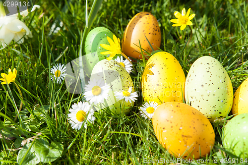 Image of colored Easter eggs hidden in flowers and grass