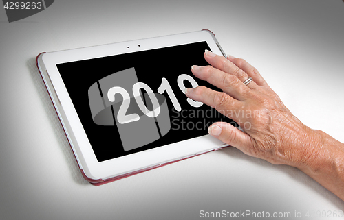 Image of Senior lady relaxing and her tablet - 2019