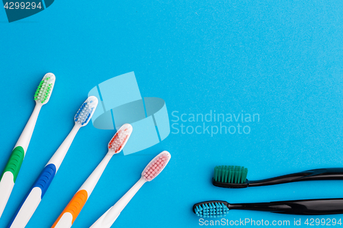 Image of Four multicolored , two black toothbrushes