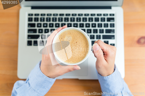 Image of Woman drink of coffee with laptop computer