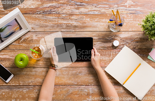 Image of hands with tablet pc and notebook at office table