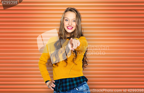Image of happy young woman or teen pointing finger to you