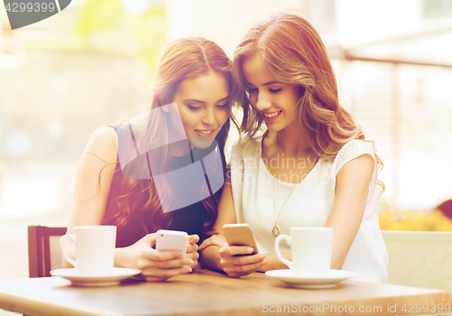 Image of women with smartphones and coffee at outdoor cafe