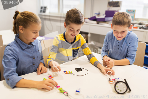 Image of happy children building robots at robotics school