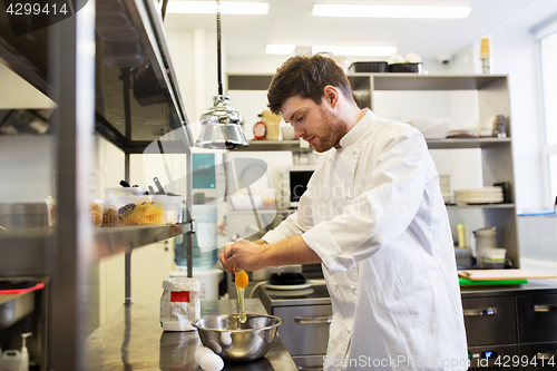 Image of happy male chef cooking food at restaurant kitchen