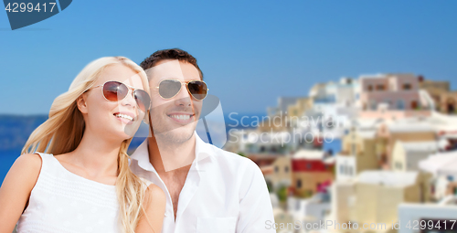 Image of happy couple in sunglasses over santorini island