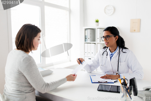 Image of doctor with clipboard and woman patient at clinic