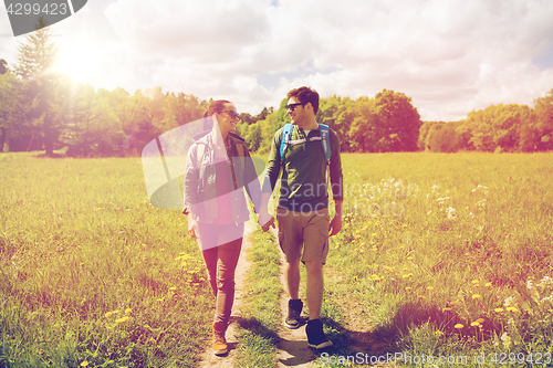 Image of happy couple with backpacks hiking outdoors