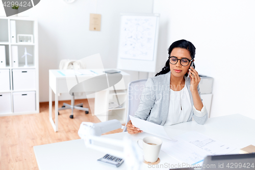 Image of businesswoman calling on smartphone at office