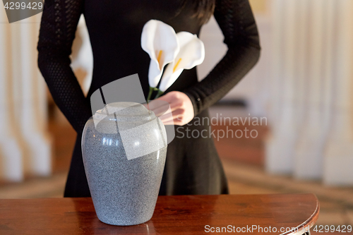 Image of woman with cremation urn at funeral in church