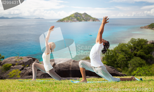 Image of couple making yoga in low lunge pose outdoors