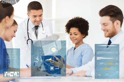 Image of group of happy doctors with tablet pc at hospital