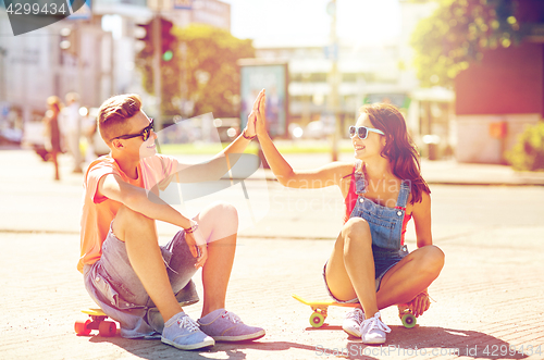 Image of teenage couple with skateboards on city street