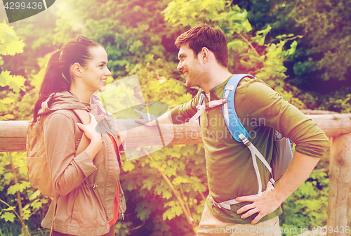 Image of smiling couple with backpacks in nature
