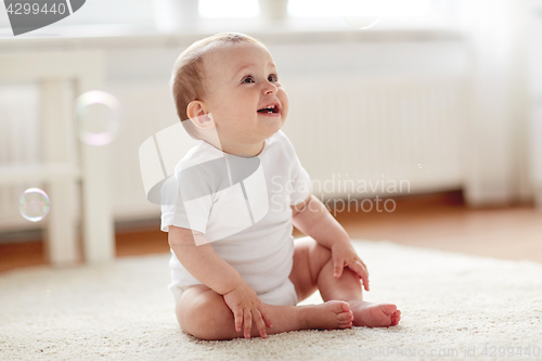 Image of happy baby with soap bubbles at home