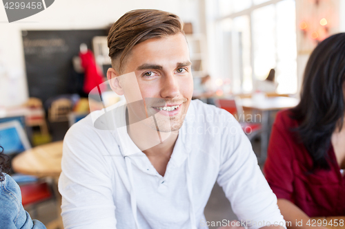 Image of happy young man with friends at restaurant