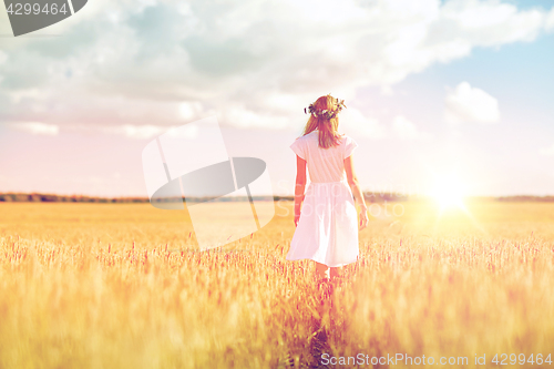 Image of happy young woman in flower wreath on cereal field