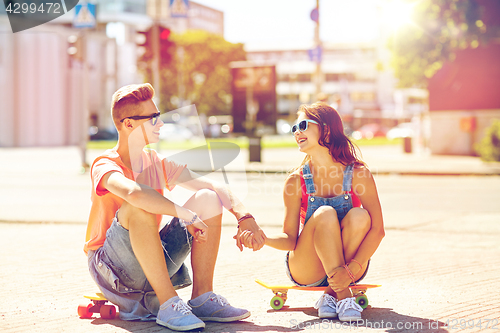 Image of teenage couple with skateboards on city street