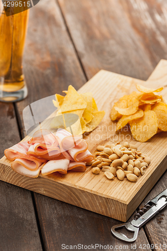 Image of Beer glass and potato chips, pistachios isolated on a white