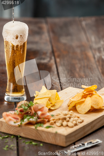 Image of Beer glass and potato chips, pistachios isolated on a white