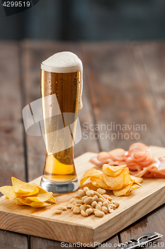 Image of Beer glass and potato chips, pistachios isolated on a white