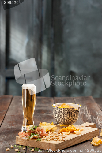 Image of Beer glass and potato chips, pistachios isolated on a white