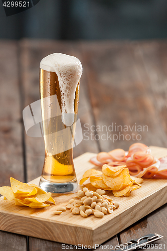 Image of Beer glass and potato chips, pistachios isolated on a white