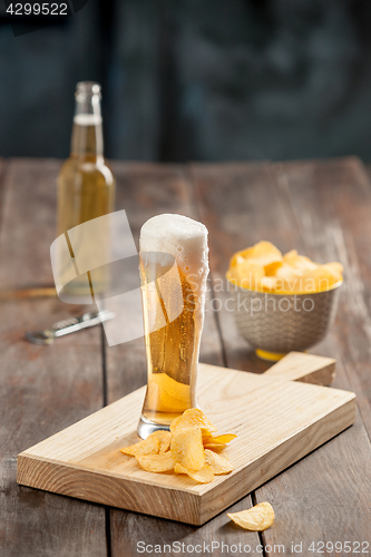 Image of Beer glass and potato chips, pistachios isolated on a white