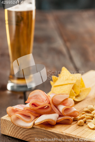 Image of Beer glass and potato chips, pistachios isolated on a white