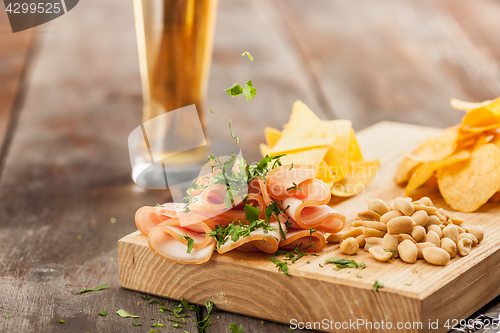 Image of Beer glass and potato chips, pistachios isolated on a white