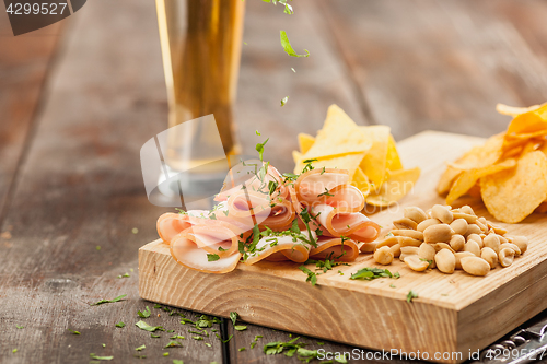 Image of Beer glass and potato chips, pistachios isolated on a white