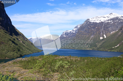 Image of A beautiful spring day with snow on the mountain peaks, blue sky