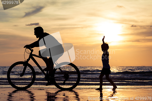 Image of Father and son playing on the beach at the day time.