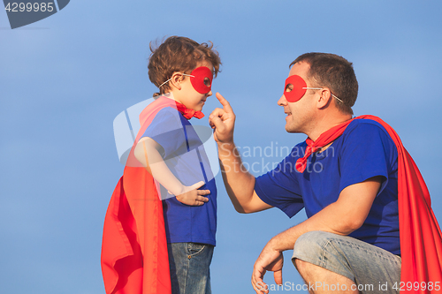 Image of Father and son playing superhero at the day time.