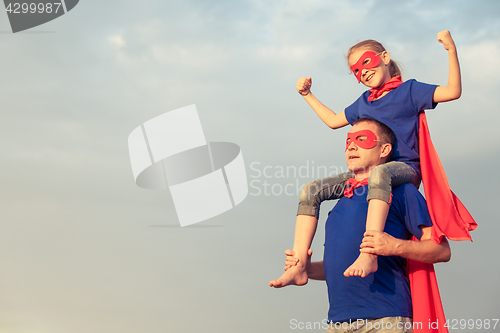 Image of Father and daughter playing superhero at the day time.