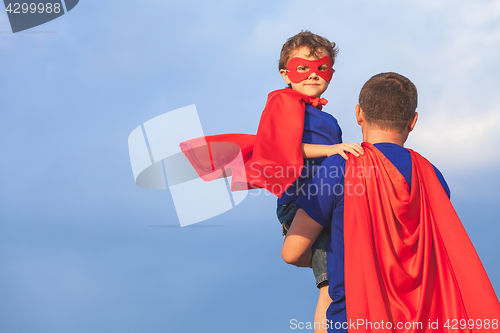 Image of Father and son playing superhero at the day time.