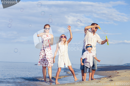 Image of Happy family walking on the beach at the day time.