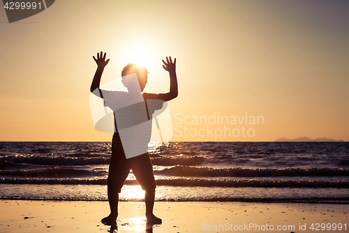 Image of Happy little boy standing on the beach 