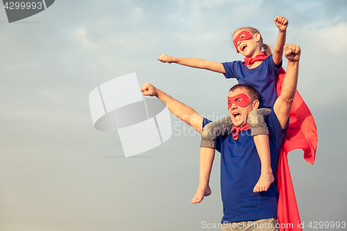 Image of Father and daughter playing superhero at the day time.