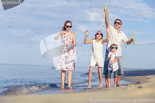 Image of Happy family walking on the beach at the day time.